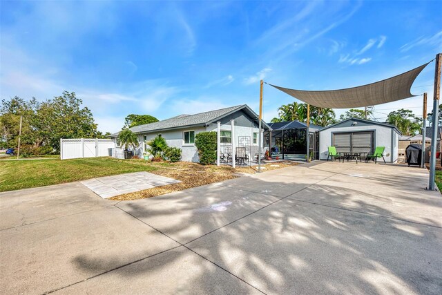 rear view of property with a lawn and a storage unit