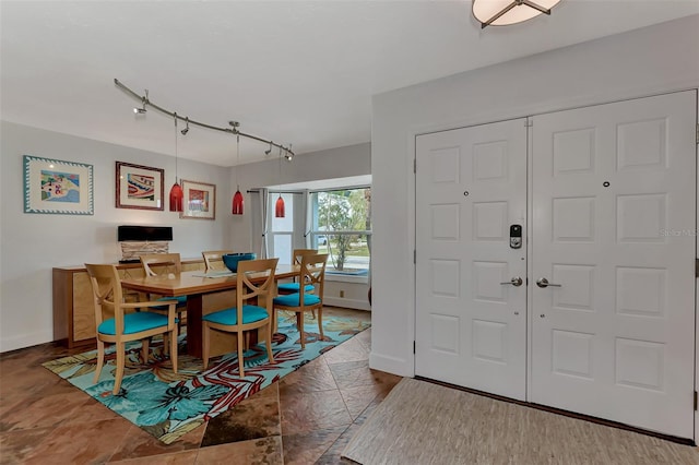 dining space with rail lighting and baseboards