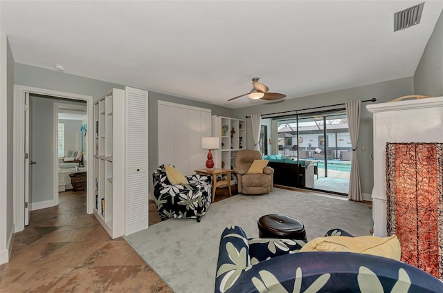 living area featuring visible vents, stone finish floor, baseboards, and a sunroom