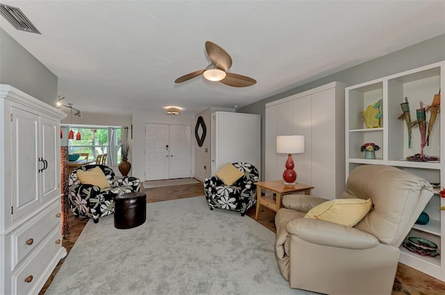 living area with visible vents and a ceiling fan