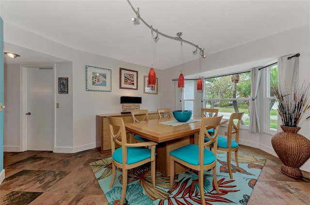 dining room with baseboards and track lighting