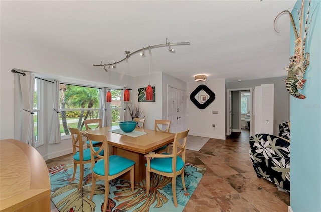 dining area with baseboards and rail lighting