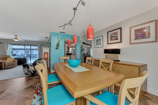 dining area featuring rail lighting and baseboards