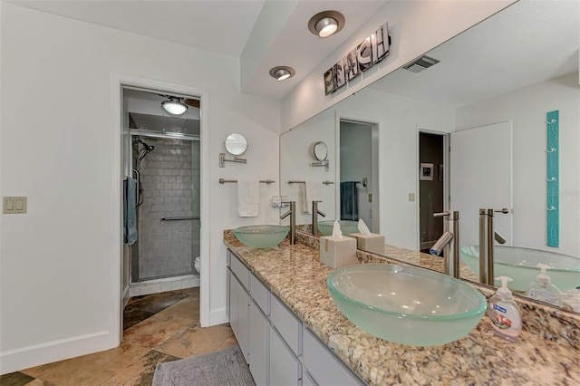 bathroom featuring toilet, a shower with door, and vanity