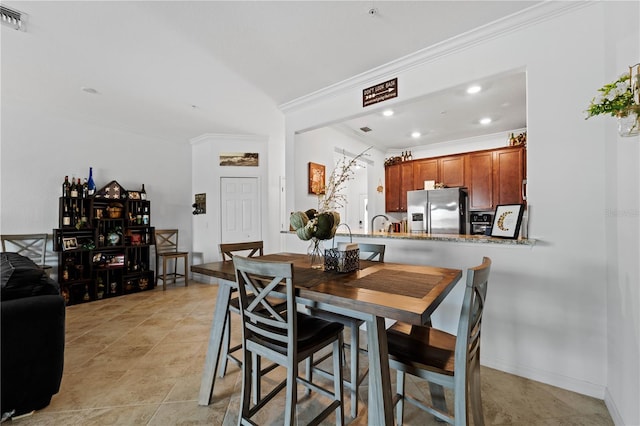 dining room with ornamental molding, light tile flooring, and sink