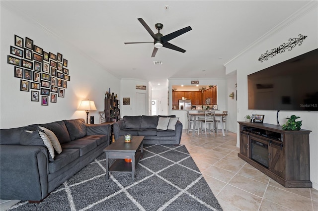 living room with light tile floors, ceiling fan, and ornamental molding