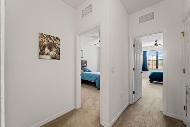 hallway featuring light colored carpet