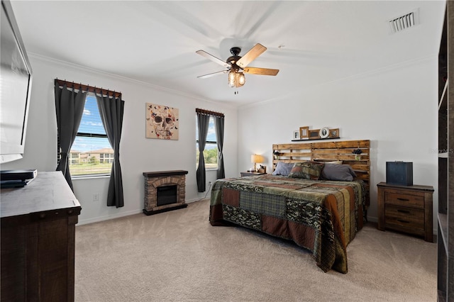 bedroom with light carpet, multiple windows, ceiling fan, and a fireplace