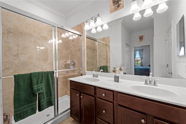 bathroom with a shower with door, dual bowl vanity, and crown molding