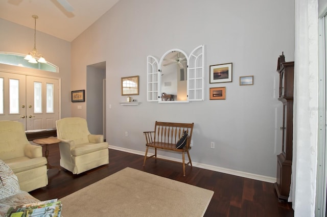 living room with high vaulted ceiling, dark wood-type flooring, and ceiling fan with notable chandelier