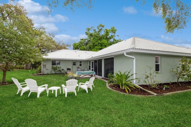 back of property featuring a sunroom and a lawn