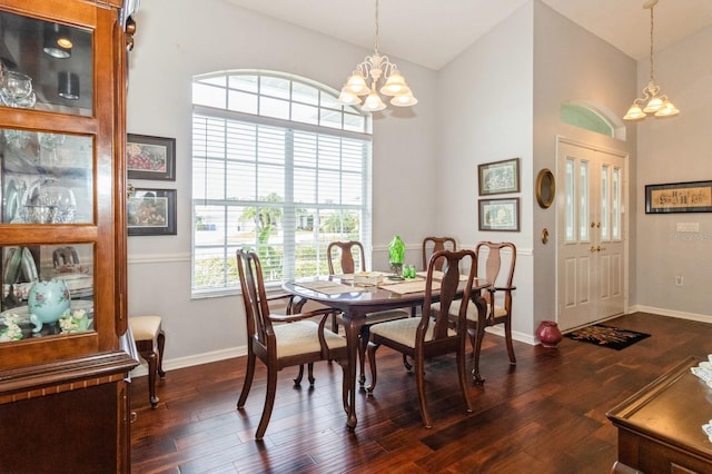 dining room featuring dark hardwood / wood-style flooring, a notable chandelier, and high vaulted ceiling