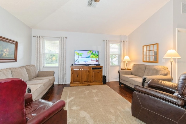 living room with lofted ceiling, a wealth of natural light, and dark hardwood / wood-style flooring