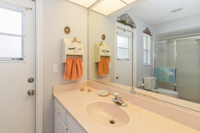 bathroom with toilet and vanity with extensive cabinet space