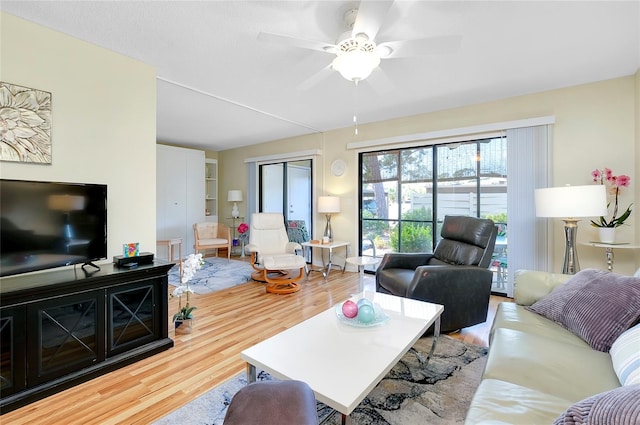 living room with ceiling fan and light wood-type flooring