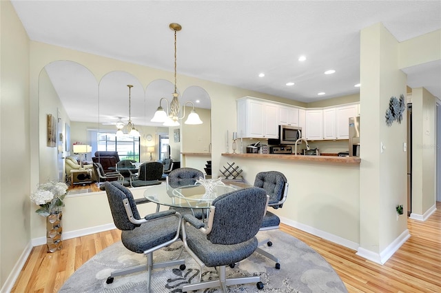 dining space with a chandelier and light hardwood / wood-style flooring