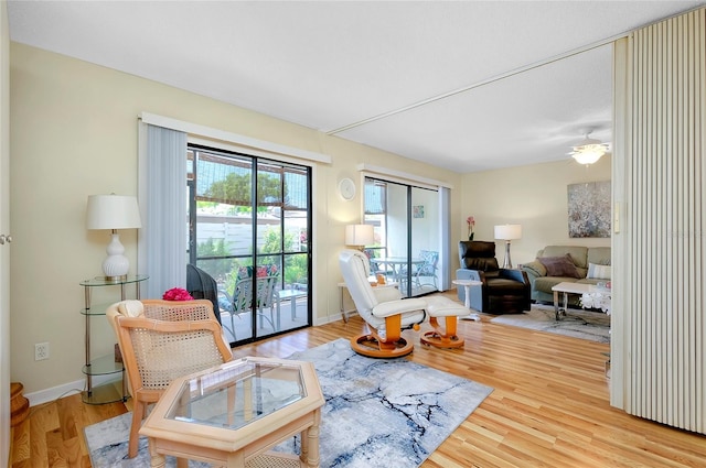 living room with ceiling fan and light wood-type flooring