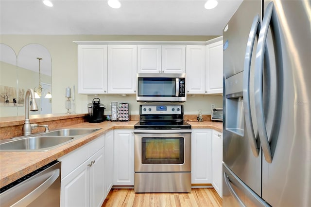 kitchen featuring white cabinets, appliances with stainless steel finishes, and light wood-type flooring