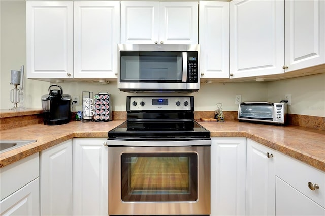 kitchen featuring stainless steel appliances and white cabinetry