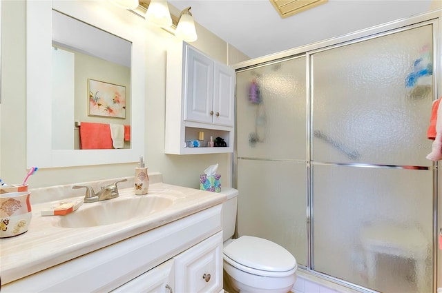 bathroom featuring walk in shower, large vanity, and toilet