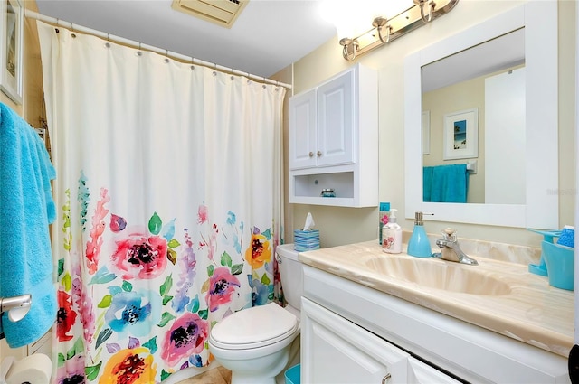 bathroom with toilet, large vanity, and tile flooring