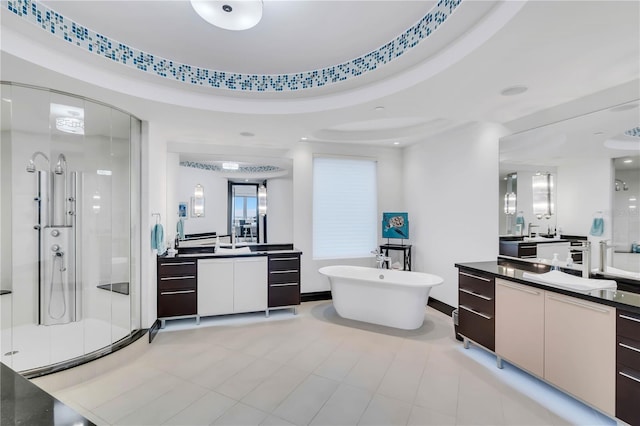 bathroom with plus walk in shower, vanity, and a tray ceiling