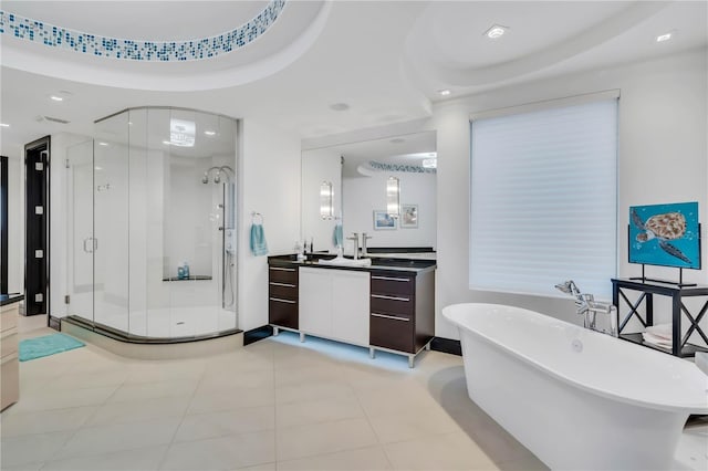 bathroom with vanity, a tray ceiling, tile patterned floors, and shower with separate bathtub