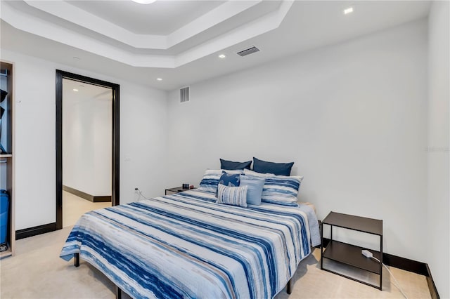 carpeted bedroom featuring a tray ceiling