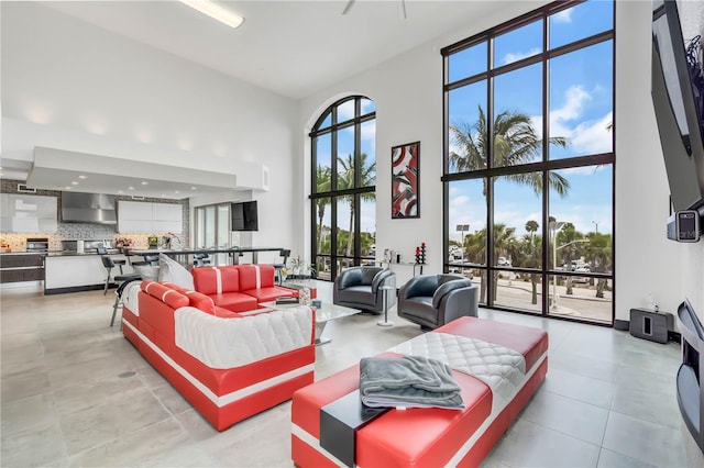 living room featuring light tile patterned flooring, floor to ceiling windows, and a high ceiling