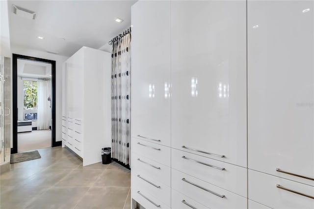 spacious closet with light tile patterned floors