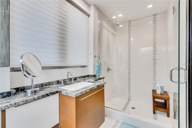 bathroom featuring vanity and a shower with shower door