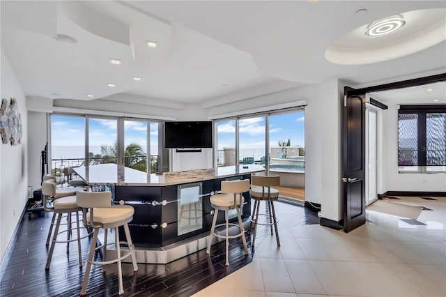 interior space featuring a wealth of natural light, a kitchen breakfast bar, and a kitchen island