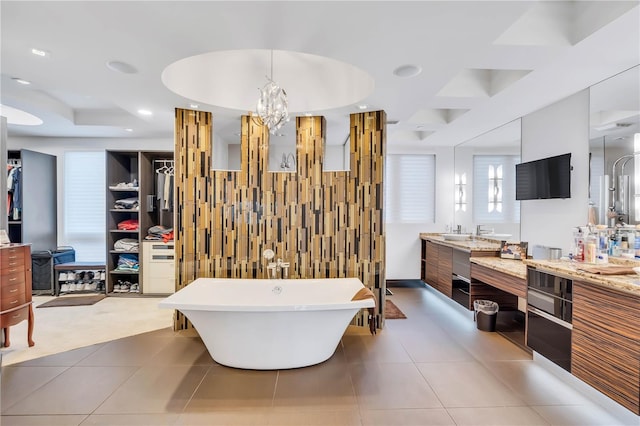 bathroom with tile patterned flooring, vanity, tile walls, and a bathtub