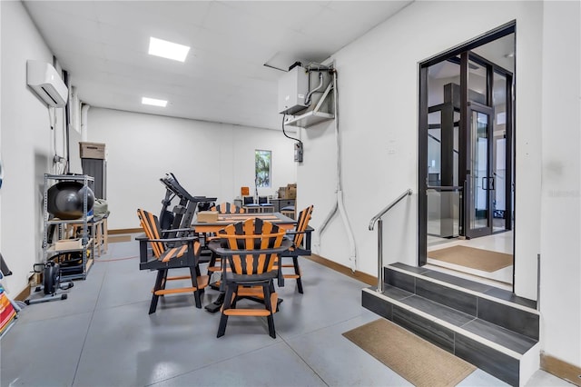 dining space featuring an AC wall unit and concrete floors