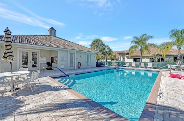 view of swimming pool featuring a patio area and french doors