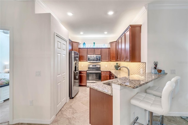 kitchen featuring kitchen peninsula, light tile floors, light stone counters, appliances with stainless steel finishes, and backsplash