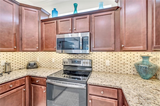 kitchen featuring appliances with stainless steel finishes, light stone counters, and tasteful backsplash