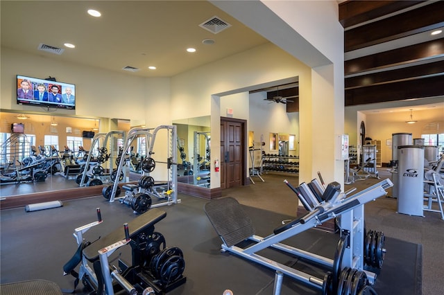 exercise room featuring a high ceiling and ceiling fan