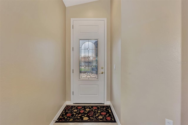 doorway to outside featuring vaulted ceiling