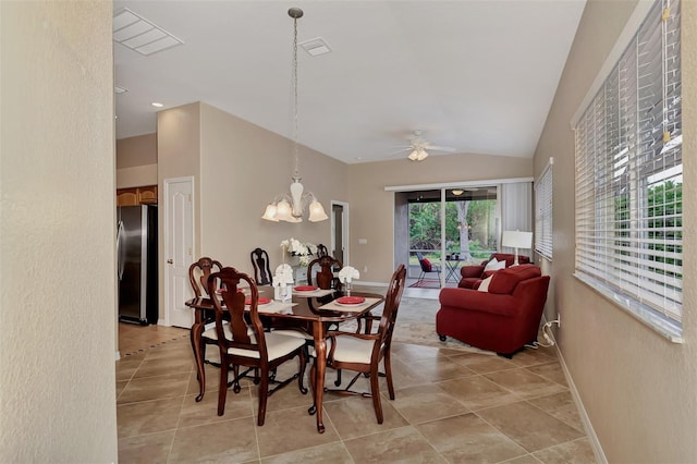 dining room featuring lofted ceiling, a healthy amount of sunlight, light tile floors, and ceiling fan with notable chandelier