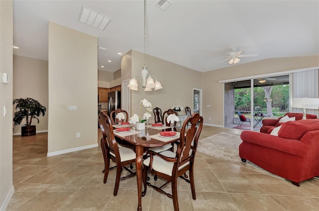 tiled dining space featuring lofted ceiling and ceiling fan with notable chandelier