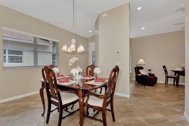 dining area with light tile floors, a notable chandelier, and vaulted ceiling