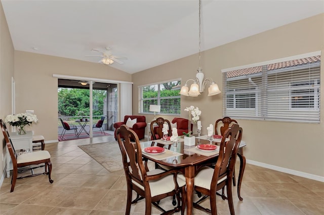 dining area with ceiling fan with notable chandelier, light tile floors, and lofted ceiling