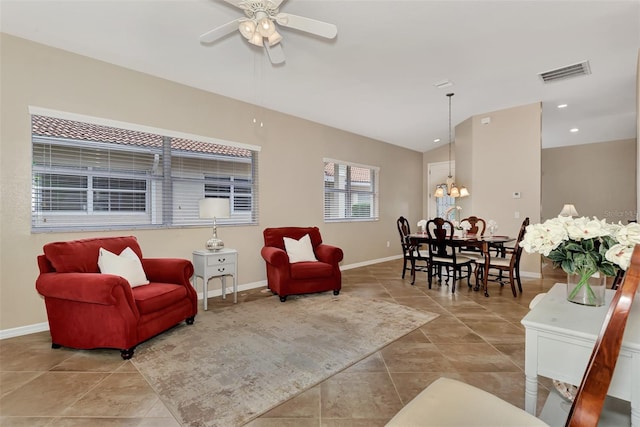 living room featuring light tile floors and ceiling fan with notable chandelier