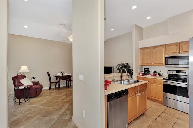 kitchen with ceiling fan, appliances with stainless steel finishes, sink, light tile floors, and light brown cabinetry