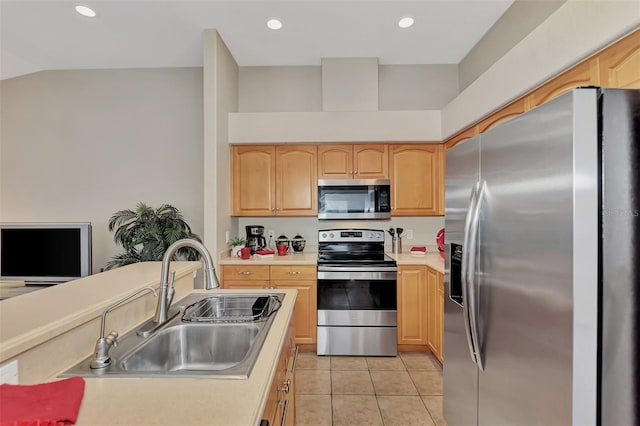 kitchen featuring light brown cabinets, stainless steel appliances, light tile floors, lofted ceiling, and sink