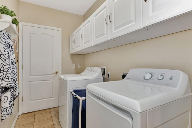 laundry area with washer hookup, light tile floors, cabinets, and washer and clothes dryer