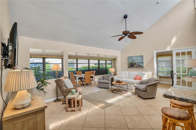 living room with high vaulted ceiling, ceiling fan, light tile floors, and a wealth of natural light