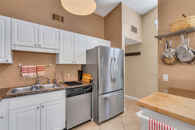 kitchen with light tile floors, white cabinets, sink, and stainless steel appliances