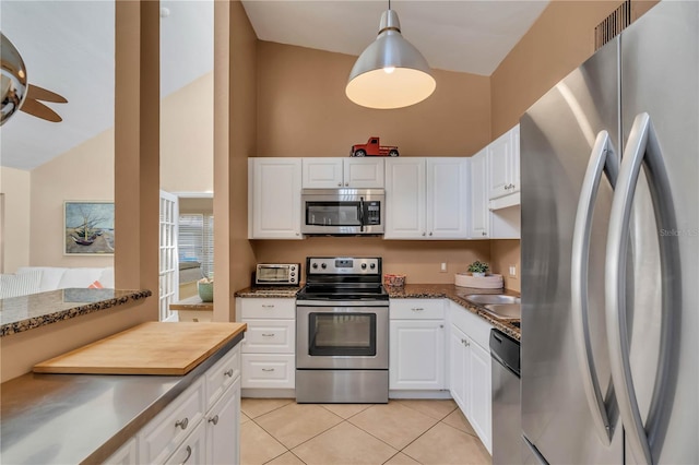 kitchen with white cabinets, pendant lighting, light tile flooring, and stainless steel appliances